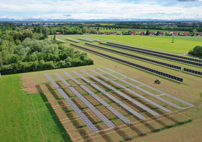 Photovoltaik-Module auf einem Feld mit Traktor